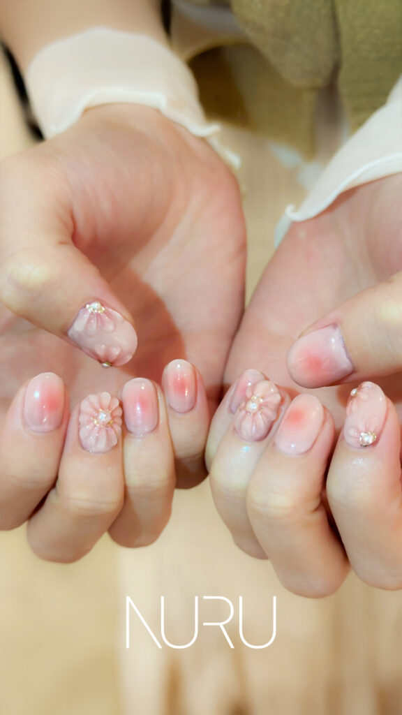 新宿西新宿ネイルサロンNURU デューブルーム sakiデザイン 新宿御苑の朝露に濡れた桜をイメージした立体フラワーネイル ピンクグラデーション パール装飾 手仕事アート 日常使いできる絶妙なバランス