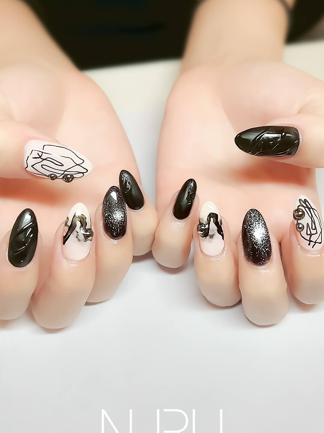 ブラック × ホワイトのモノトーンに、線画アートが映える個性派ネイル