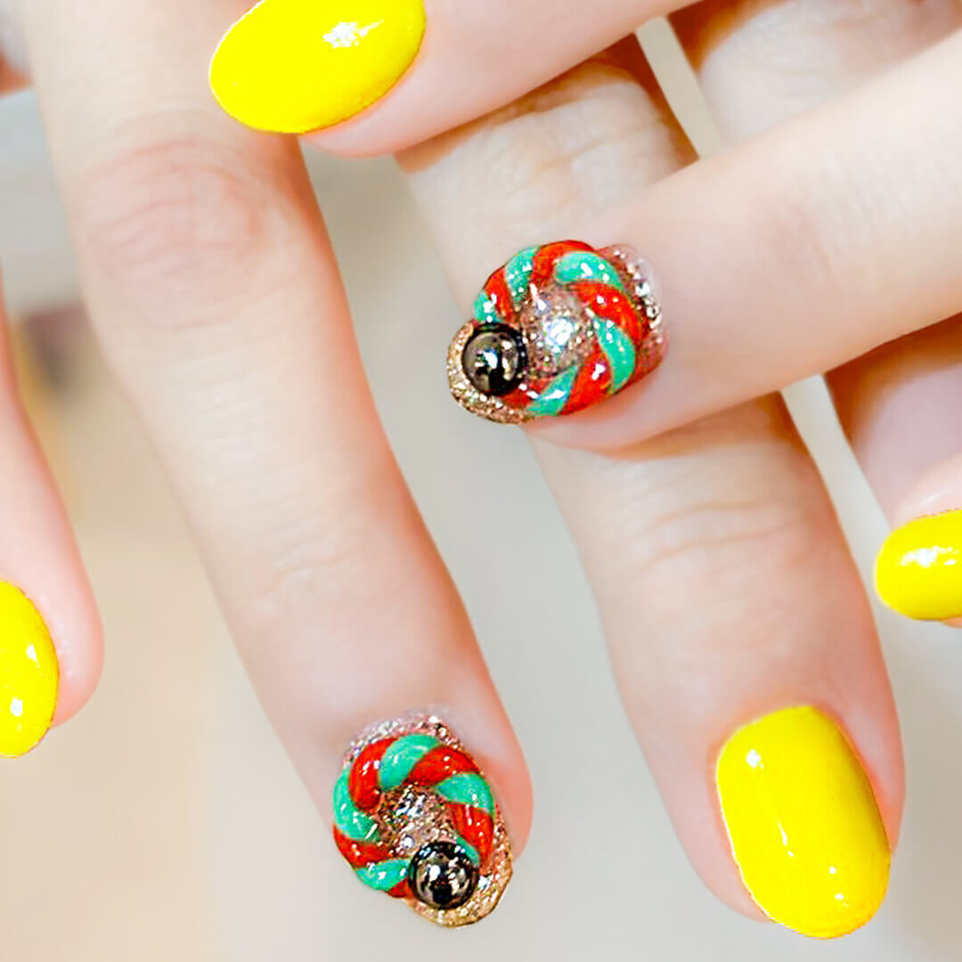 イエローに立体感あるツイストアートを組み合わせた個性派ネイル