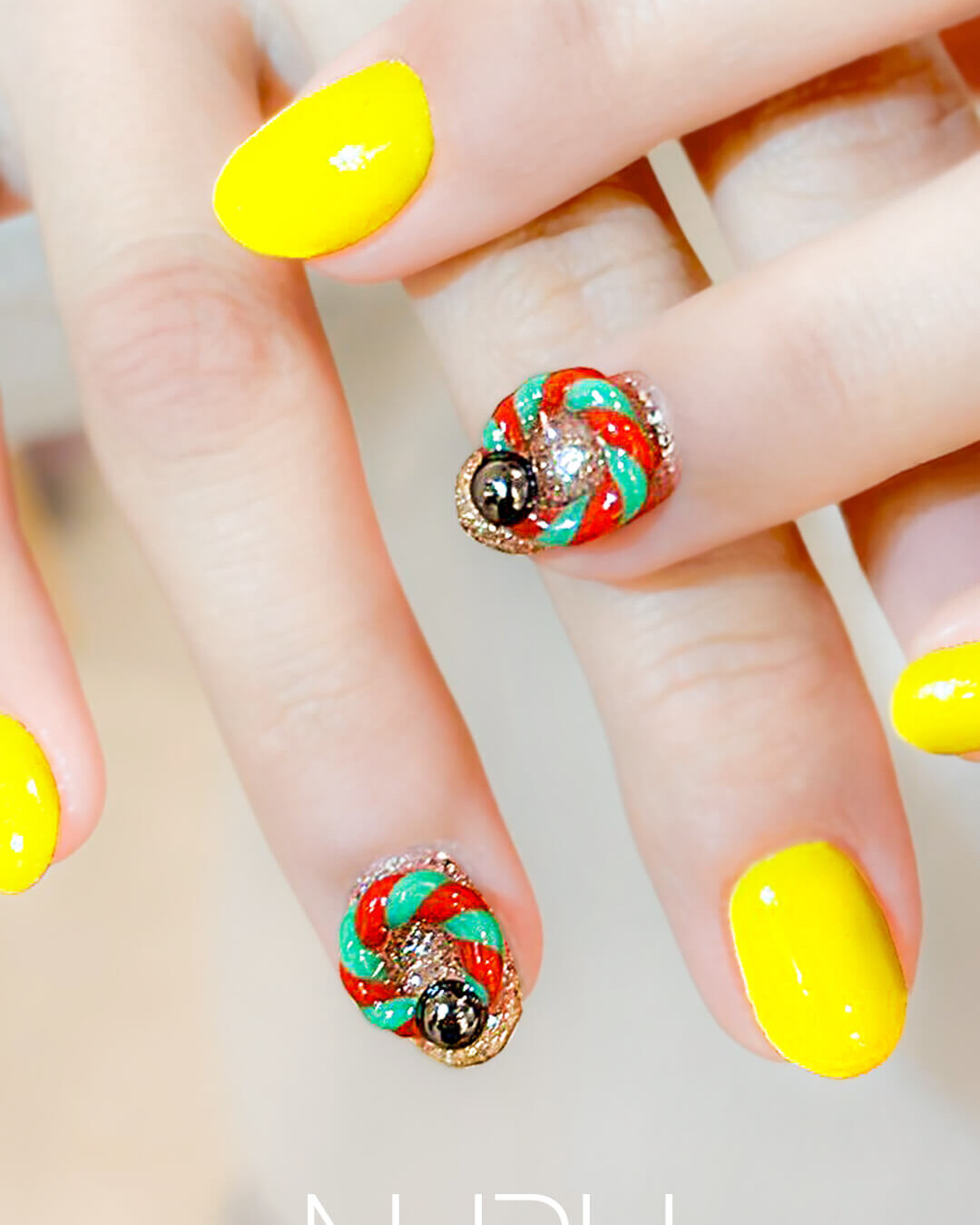 イエローに立体感あるツイストアートを組み合わせた個性派ネイル