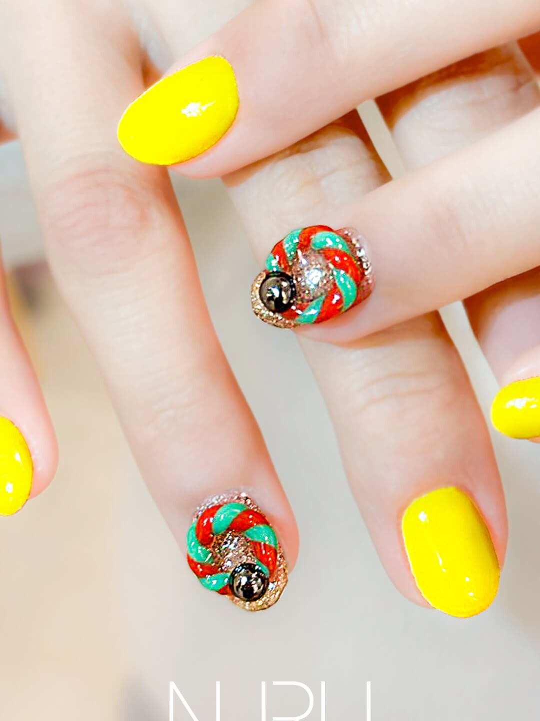 イエローに立体感あるツイストアートを組み合わせた個性派ネイル