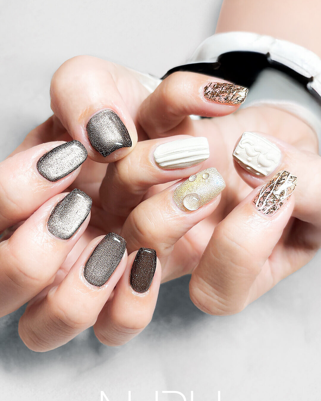 グレーのシックなマグネットネイルと、マットなニット＆雫アートを合わせた、上級者アシメネイル