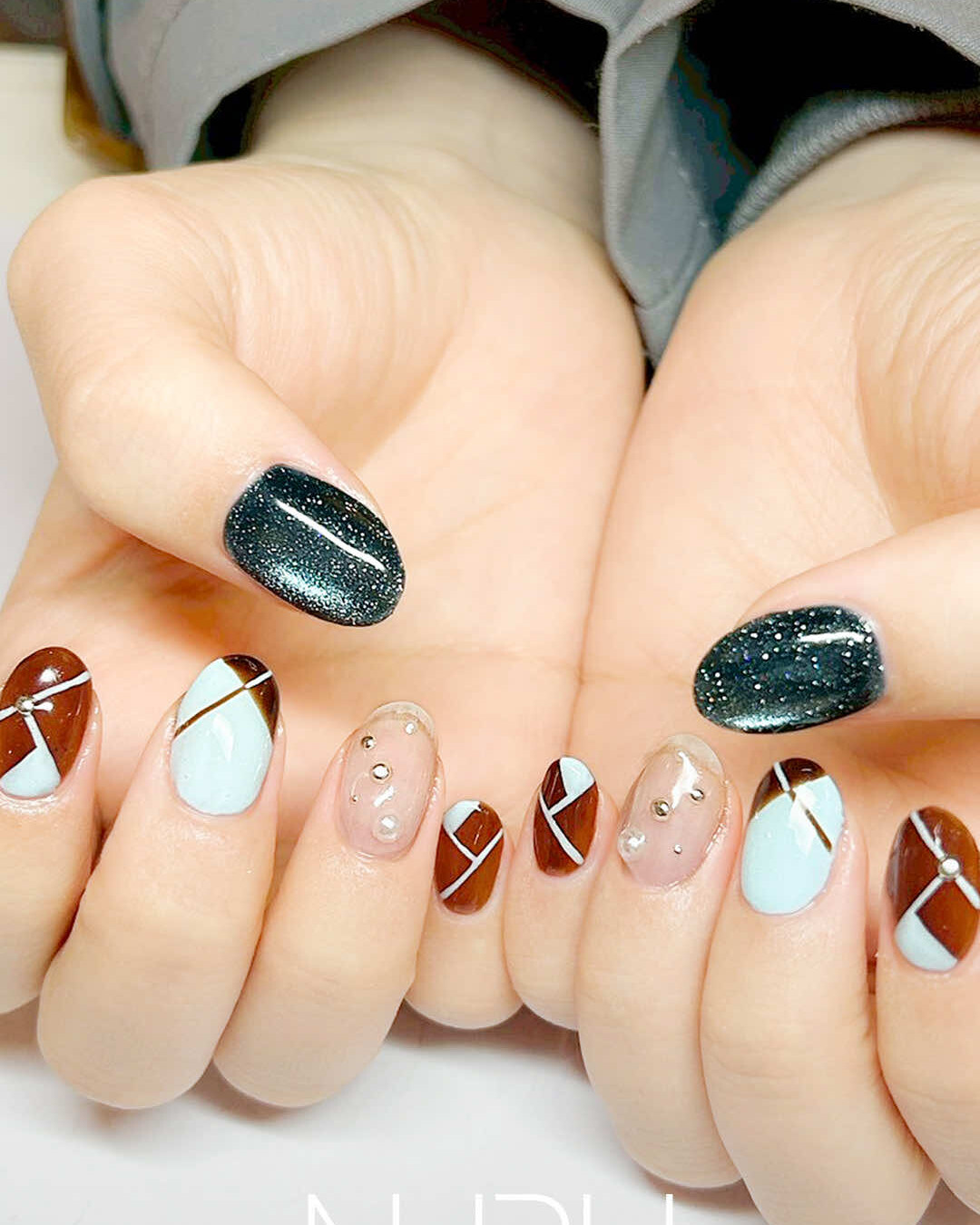 パステルブルー×キャラメルブラウンに、深みのあるブルーのマグネットネイルを合わせ