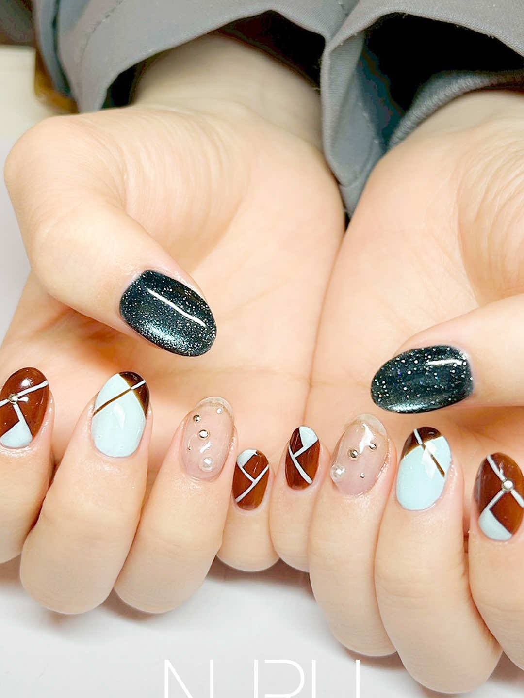 パステルブルー×キャラメルブラウンに、深みのあるブルーのマグネットネイルを合わせ