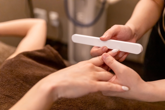 丁寧にネイル施術をするネイリスト